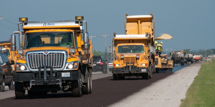 two trucks working on road