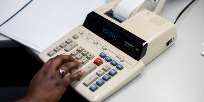 a worker types on a calculator