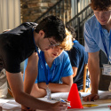 Interns around a table strategize to complete a task